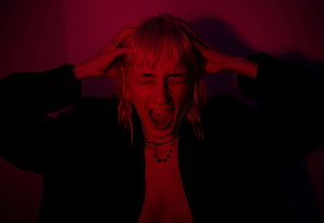 Mujer con las manos en la cabeza, mostrando una expresión de preocupación o estrés.